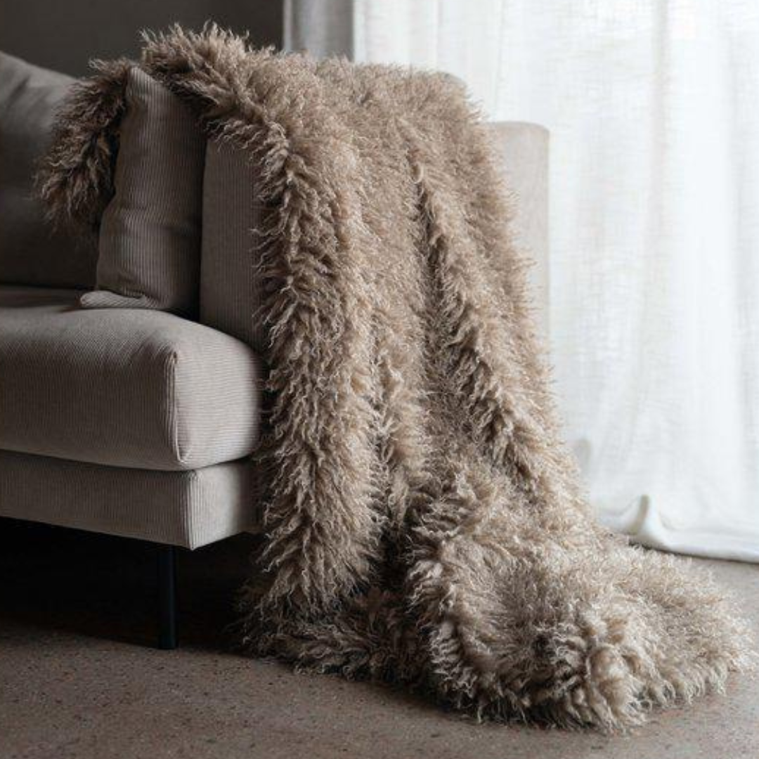Curly pläd sand 120x150 cm draperad över beige soffa